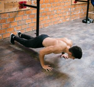 A fit man performs push-ups in a Ciudad de México gym, showcasing strength and dedication.