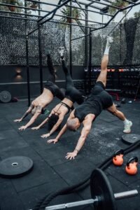 Three people engaged in a dynamic workout session in a Mexico City gym, showcasing fitness and teamwork.